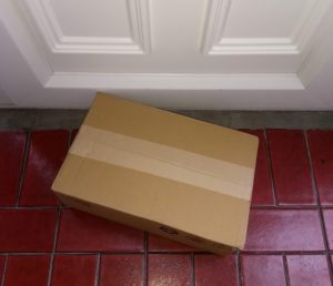 Plain cardboard box on doorstep - Greener logistics would reduce our impact as consumers.