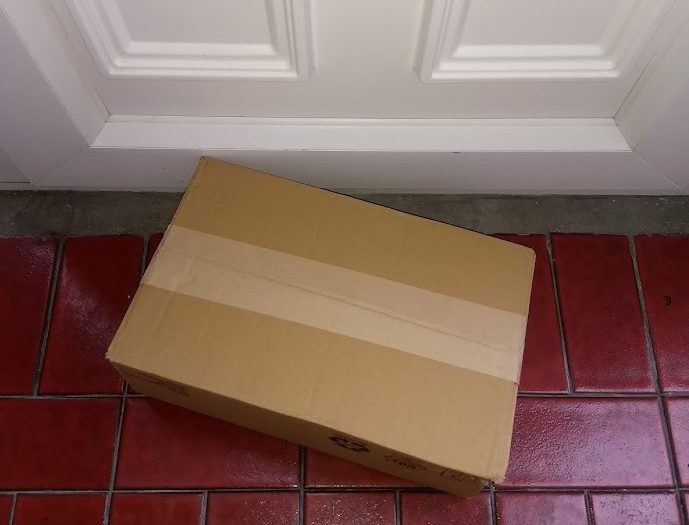 Plain cardboard box on doorstep - Greener logistics would reduce our impact as consumers.